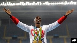 FILE - Britain's Mo Farah celebrates winning the gold medal at the men's 5,000-meter medals ceremony at the 2016 Summer Olympics in Rio de Janeiro, Brazil. 8.20.2016
