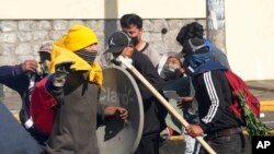 Un manifestante herido es ayudado por sus compañeros durante enfrentamientos con la policía en medio de protestas contra el gobierno del presidente ecuatoriano Guillermo Lasso en Quito, Ecuador, el jueves 23 de junio de 2022.