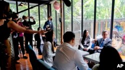 U.S. Secretary of State Antony Blinken, right, meets with U.S. Exchange Alumni at a cafe in Bangkok, July 10, 2022. 