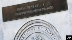 FILE - A sign for the Department of Justice Federal Bureau of Prisons is displayed at the Metropolitan Detention Center in the Brooklyn borough of New York, July 6, 2020. 