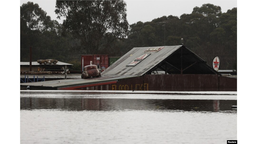 Tanda "tingkat ketinggian air" dari banjir yang sebelumnya, terlihat sebagian terendam di sisi bangunan, menyusul hujan lebat di pinggiran Londonderry di Sydney, Australia, 5 Juli 2022. REUTERS/Loren Elliott