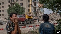 Iryna Shulimova, de 59 años, llora ante los destrozos que dejó un cohete ruso en un bloque de apartamentos en Chasiv Yar, en la región de Donetsk, en el este de Ucrania, el domingo 10 de julio de 2022. (AP Foto/Nariman El-Mofty)