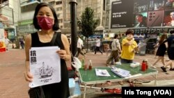 陳寶瑩（手持傳單者）6月25日七一前最後一個週末，在銅鑼灣擺街站，呼籲市民關註一國兩制。(美國之音 湯惠芸)