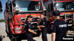 Romanian firefighters, who will reinforce their Greek colleagues during the summer season to tackle wildfires in the country, stand next to their vehicles, in Athens, Greece, July 2, 2022.