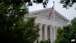 FILE - An American flag waves in front of the U.S. Supreme Court building, June 27, 2022, in Washington.