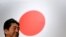 រូបឯកសារ៖ លោក Shinzo Abe អតីតនាយករដ្ឋមន្ត្រីជប៉ុន ឈរនៅមុខទង់ជាតិជប៉ុន ក្រោយពីចូលរួមសមាជបក្សប្រជាធិបេតយ្យសេរីនិយម (LDP) នៅទីក្រុងតូក្យូ ប្រទេសជប៉ុន កាលពីថ្ងៃទី ៥ ខែមីនា ឆ្នាំ ២០១៧។