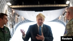 El primer ministro británico, Boris Johnson, a bordo de un C-17, después de llegar a su país, luego de una visita sorpresa a Ucrania para reunirse con el presidente Volodymyr Zelensky en Kiev, en Oxfordshire, Gran Bretaña, el 18 de junio de 2022. Joe Giddens/Pool vía REUTERS