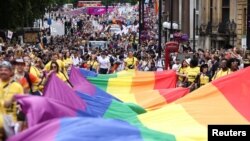 People carry a large rainbow flag as they take part in the 2022 Pride Parade in London, 2 July 2022.