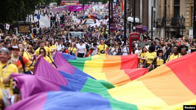 People carry a large rainbow flag, as they take part in the 2022 Pride Parade in London, July 2, 2022.