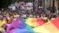 Para peserta pawai membentangkan bendera pelangi dalam pawai Pride 2022 di Kota London, Inggris, untuk memperingatai kesetaraan kaum LGBTQ+, Sabtu, 22 Juli 2022. (Foto: Henry Nicholls/Reuters)
