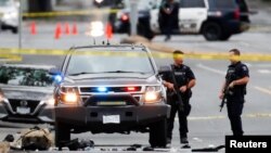 Des policiers se rassemblent après des échanges de tirs près d'une banque à Saanich, en Colombie-Britannique, au Canada, le 28 juin 2022.