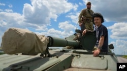 Ukrainian soldiers ride a self-propelled artillery vehicle Gvozdika in the Donetsk region, Ukraine, June 17, 2022.