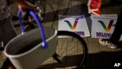 Supporters of hard-left leader Jean-Luc Melenchon prepare electoral posters and glue ahead of the second round of the legislative elections in Strasbourg, eastern France, June 14, 2022.