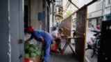 A man eats dinner behind the barrier of a residential area, amid new lockdown measures in parts of the city to curb the COVID-19 outbreak in Shanghai, China, June 24, 2022. 