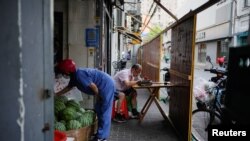 A man eats dinner behind the barrier of a residential area, amid new lockdown measures in parts of the city to curb the COVID-19 outbreak in Shanghai, China, June 24, 2022. 