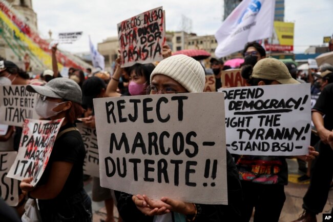 Activists hold placards against the inauguration ceremony of President-elect Ferdinand Marcos Jr. during a protest in Manila, Philippines on Thursday, June 30, 2022. (AP Photo/Basilio Sepe)