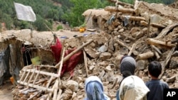 Afghan children stand near a house that was destroyed in an earthquake in the Spera district of the southwestern part of Khost Province, Afghanistan, June 22, 2022.