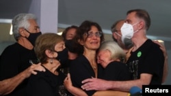 Alessandra Sampaio, esposa del periodista británico Dom Phillips, asesinado en la Amazonía junto con el experto indígena Bruno Pereira, es abrazada por su familia, durante el funeral del periodista en Niteroi, cerca de Río de Janeiro, Brasil, 26 de junio de 2022.