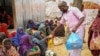 FILE - Somalis who fled drought-stricken areas receive charitable food donations from city residents after arriving at a makeshift camp for the displaced on the outskirts of Mogadishu, Somalia, June 30, 2022. 