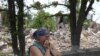 Ukrainian inhabitant, Raisa, reacts next to a destroyed school in the village of Bilogorivka not far from Lysychansk, Lugansk region, on June 17, 2022, amid the Russian invasion of Ukraine. 