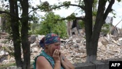 Ukrainian inhabitant, Raisa, reacts next to a destroyed school in the village of Bilogorivka not far from Lysychansk, Lugansk region, on June 17, 2022, amid the Russian invasion of Ukraine. 