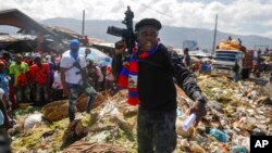 DOSSIER - Barbecue, le leader du "G9 et famille" gang, se tient à côté des ordures pour attirer l'attention sur les conditions de vie des gens alors qu'il dirige une marche contre les enlèvements dans le quartier de La Saline à Port-au-Prince, Haïti, le 22 octobre 2021.