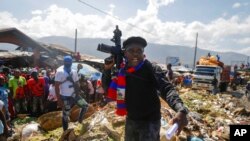 Barbecue, ketua dari geng "G9 and Family", berdiri di dekat tumpukan sampah untuk meningkatkan kesadaran tentang kondisi kehidupan warga Haiti dalam sebuah aksi di area La Saline di Port-au-Prince, Haiti, pada 22 Oktober 2021. (Foto: AP/Odelyn Joseph)