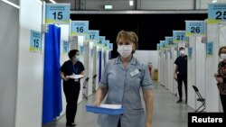 FILE - A nurse carries a tray of COVID-19 vaccine boosters at a vaccination site in Dublin, Ireland, Jan. 12, 2022.