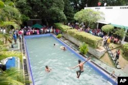 Para pengunjuk rasa berenang di kolam renang kediaman resmi presiden, sehari setelah diserbu di Kolombo, 10 Juli 2022. (Foto: AP)