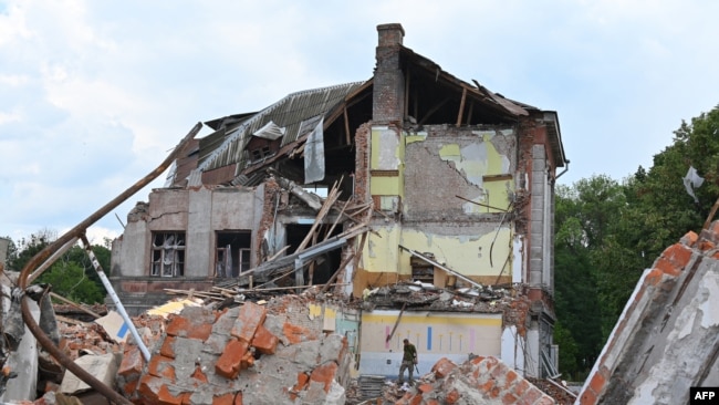 Un militar ucraniano inspecciona las ruinas del edificio Lyceum, que se sospecha que fue destruido después de un ataque con misiles cerca de Kharkiv el 5 de julio de 2022, en medio de la invasión rusa de Ucrania.