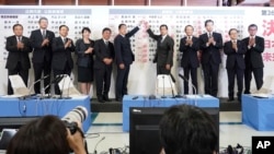 기시다 후미오(왼쪽 6번째) 일본 총리가 10일 참의원 선거 개표 상황실에서 당선 확정된 자민당 후보 이름에 꽃으로 표시하고 있다. 