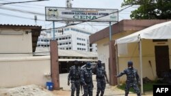 Des policiers devant les locaux de la Commission électorale nationale autonome (CENA) le 12 avril 2021, après les élections présidentielles du pays. (Photo PIUS UTOMI EKPEI / AFP)