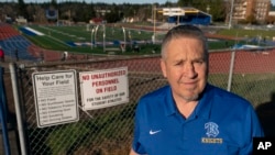 Joe Kennedy, a former assistant football coach at Bremerton High School in Bremerton, Wash., poses for a photo March 9, 2022, at the school's football field. (AP Photo/Ted S. Warren)