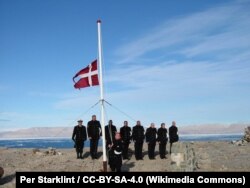 Представители Дании в очередной раз водружают флаг над островом в 2003 году. Позже флаг будет вновь заменен на канадский
