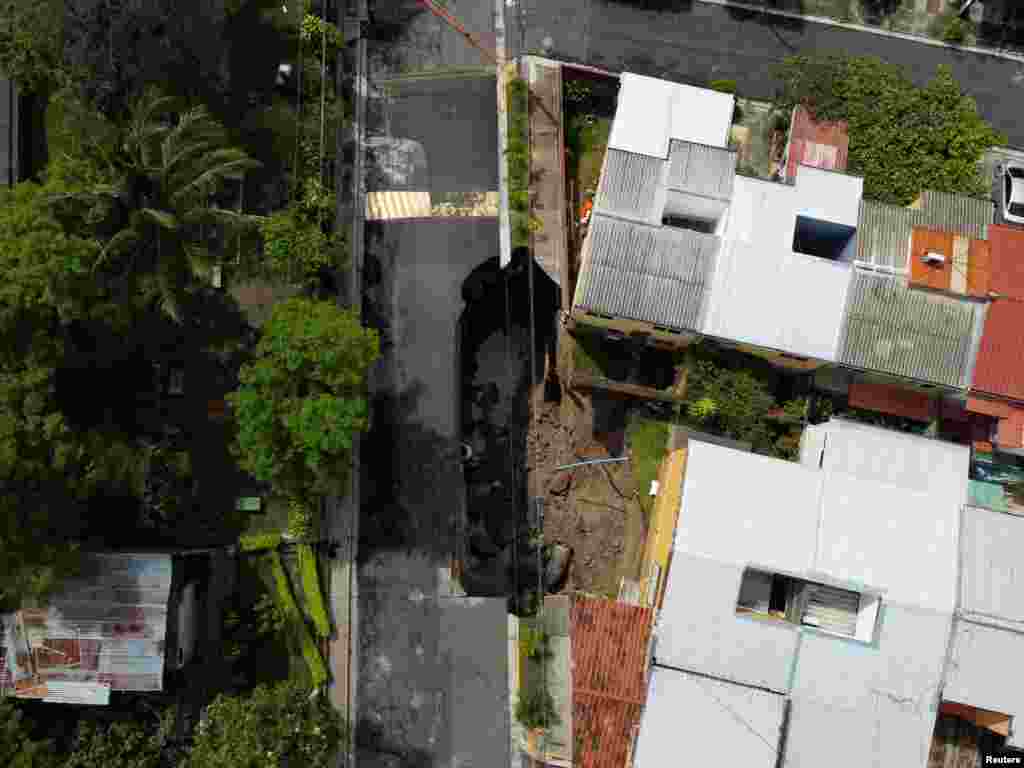 Una calle colapsó después de una inundación causada por fuertes lluvias de la tormenta tropical Bonnie en San Salvador, El Salvador, el 3 de julio de 2022.