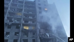 FILE: In this photo provided by the Ukrainian Emergency Service, first responders try to extinguish flames at a residential building in Odesa, Ukraine, early Friday, July 1, 2022, following Russian missile attacks. 