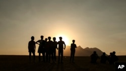 FILE - In this Aug. 17, 2021, photo, young men who say they deserted the Afghan military and fled to Turkey through Iran stand in the countryside in Tatvan, in Bitlis province, eastern Turkey.