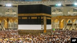 In this photo taken with low shutter speed, Muslim pilgrims circumambulate the Kaaba at the Grand Mosque, Mecca, Saudi Arabia, July 6, 2022. Muslims are converging on Mecca for the largest hajj since the coronavirus pandemic curtailed access.