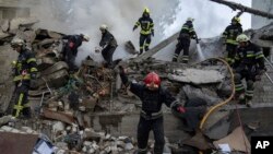 Rescue workers clearing rubble of a destroyed school after an attack in Kharkiv, Ukraine, July 4, 2022. 