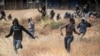 Migrants run on Spanish soil after crossing the fences separating the Spanish enclave of Melilla from Morocco in Melilla, Spain, June 24, 2022.