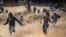 FILE: Migrants run on Spanish soil after crossing the fences separating the Spanish enclave of Melilla from Morocco in Melilla, Spain, June 24, 2022.