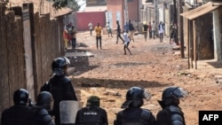 Des manifestants lancent des pierres à la police anti-émeute lors d'une manifestation non autorisée appelée par l'opposition contre le président à Conakry le 5 mars 2020