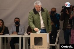 El presidente saliente, Iván Duque Márquez, deposita su boleta de votación luego de ejercer su derecho al voto el domingo 19 de junio de 2022, en la segunda vuelta electoral en Colombia. [Foto cortesía presidencia de Colombia].