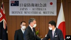 澳大利亞國防部長馬勒斯和日本防務大臣岸信夫在東京舉行聯合記者會後握手。 （2022年6月15日）