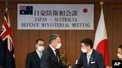 Wakil Perdana Menteri dan Menteri Pertahanan Australia Richard Marles, kiri, dan Menteri Pertahanan Jepang Nobuo Kishi berjabat tangan setelah konferensi pers bersama di Kementerian Pertahanan pada Rabu, 15 Juni 2022, di Tokyo. (Foto: AP)