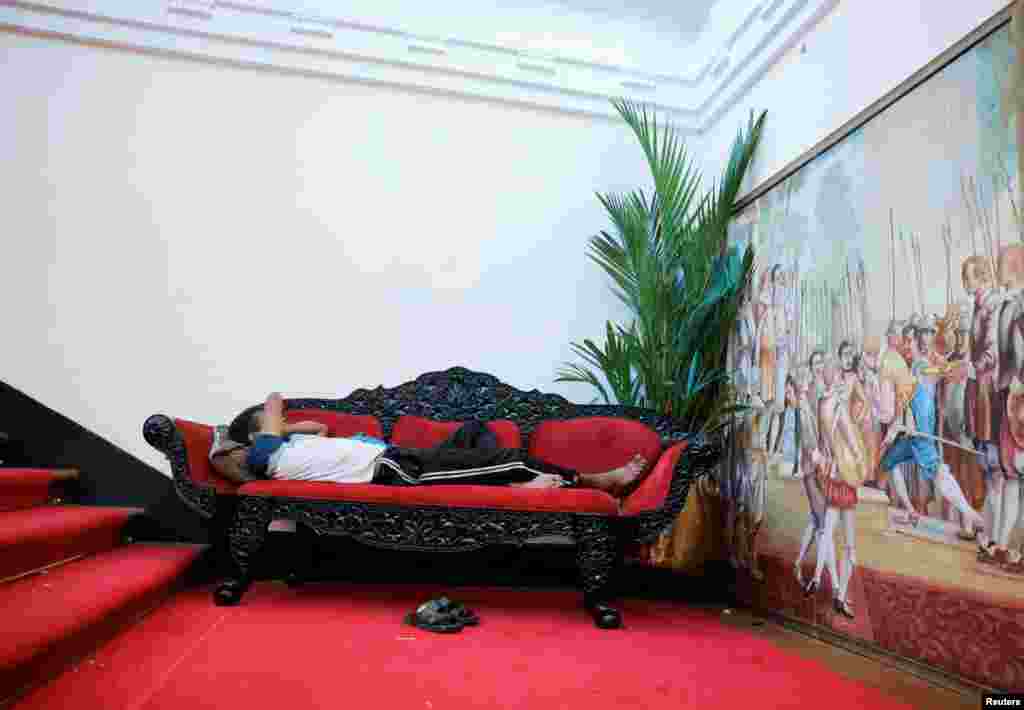 Un hombre duerme en un sofá dentro de la casa del presidente.