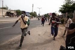 Protesters run from tear gas in Dakar, Senegal Friday, June 17, 2022. (Annika Hammerschlag/VOA)
