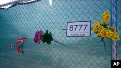 Artificial flowers are shown on a fence on June 21, 2022, surrounding the site where the Champlain Towers South collapsed killing 98 people last year in Surfside, Fla. 