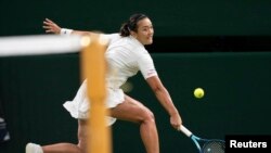 Harmony Tan of France returns a shot during her first round match against Serena Williams of the United States on day two at All England Lawn Tennis and Croquet Club. Photo Credit: Susan Mullane, USA TODAY Sports.