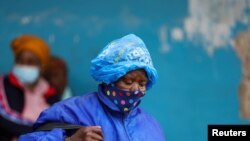 FILE - A woman wearing a protective face mask against the coronavirus disease (COVID-19) in Tsomo, a town in the Eastern Cape province of South Africa, Dec. 2, 2021.